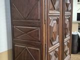 a large wooden armoire in the corner of a room