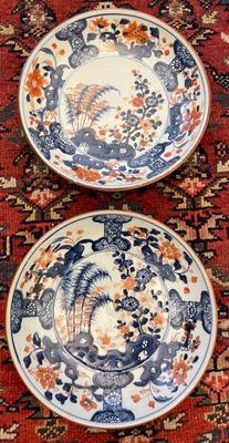 two plates that are sitting on a red rug