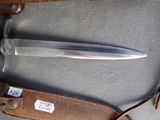 a knife that is laying on a piece of luggage