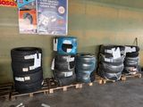 many tires lined up on a pallet in a garage