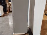 two refrigerators that are sitting on pallets in a warehouse