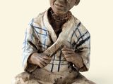une figurine représentant un homme assis par terre