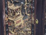 a black cabinet with a painting on the door