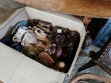 une boîte remplie d'objets hétéroclites posée sur le sol