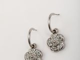 a pair of silver earrings on a white surface
