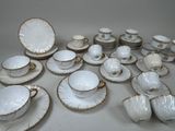 a lot of white and gold china dishes and cups