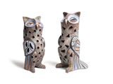 deux figurines de chouettes assises l'une à côté de l'autre sur une surface blanche