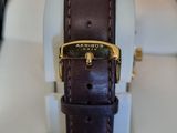 brown leather strap on a watch with a gold buckle