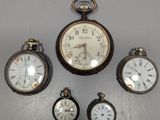 cinq types différents de montres de poche exposées au mur
