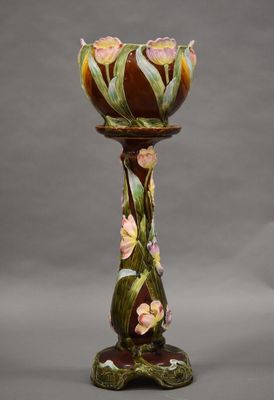 un gros plan d'un vase posé sur un socle et orné de fleurs