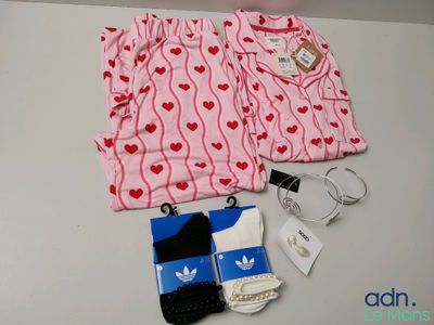 un pyjama rose et blanc, des chaussettes et un téléphone portable posés sur une table
