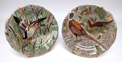 deux assiettes sur lesquelles sont peints des oiseaux sur un fond blanc