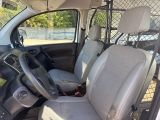 the interior of a small van with two seats and a steering wheel