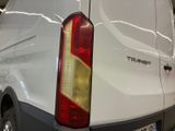 a white van parked in a showroom with its lights on