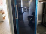 une porte bleue avec un seau à l'intérieur, dans une pièce