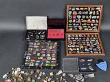 an assortment of pins and brooches in a wooden case