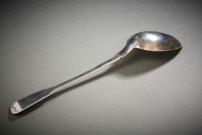 a silver spoon with a spoon handle on a table