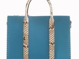 a blue and white handbag with snakes on the handle