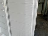 a white refrigerator with its door open in a garage