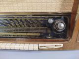 an old fashioned radio sitting on top of a table next to a wall
