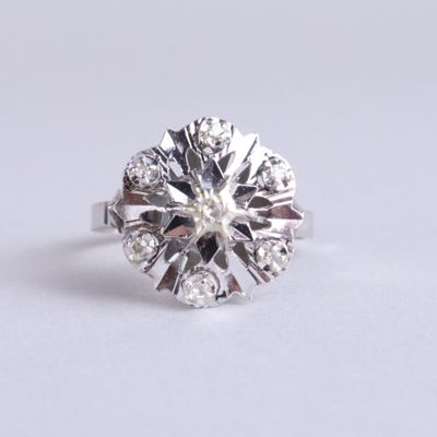 une image d'une bague en diamant sur une surface blanche
