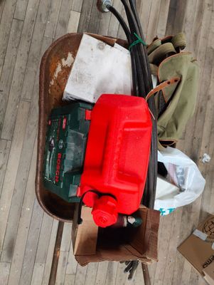 a red container sitting on top of a wheelbarrower