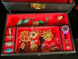 a red box with a bunch of jewelry inside of it