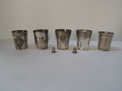 six coupes en argent ornées de motifs, posées sur une surface blanche