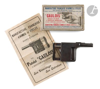 un vieux pistolet est posé à côté d'un paquet de cigarettes