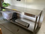 une table de travail en acier inoxydable sur laquelle se trouve un rouleau de papier