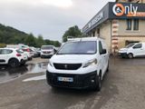 une petite camionnette blanche garée devant un bâtiment