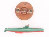un sous-marin miniature et un bateau miniature posés sur une surface blanche