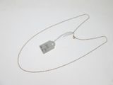 un collier en argent muni d'une pendentif, posé sur une surface blanche