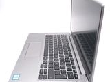 a silver laptop with a black keyboard on a white surface