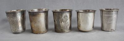 six silver cups are lined up in a row on a table