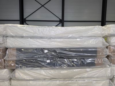 a large pile of mattresses sitting in a warehouse