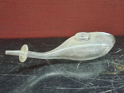 a glass object on a table with a red wall in the background