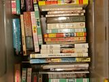 many books stacked in a plastic box on the floor