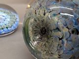 a glass ornament sitting next to another glass ornament on a table