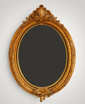 a gold oval mirror hanging on a wall next to a white wall