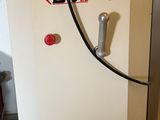 a white refrigerator with a hose attached to it in a room