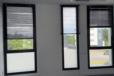 a room with three windows and a ceiling fan in it