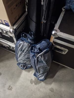 two bags of luggage sitting next to a stack of suitcases