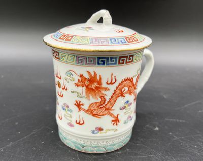 une image représentant une tasse ornée d'un dragon, posée sur une table