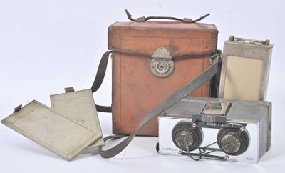 une valise, un appareil photo et un livre posés sur une table