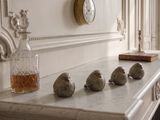cinq petits oiseaux perchés sur une cheminée, à côté d'une horloge