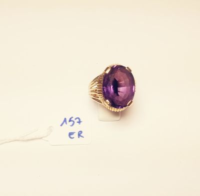 an amethorate ring with a purple stone surrounded by a gold band