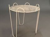 an image of a white wire table on a grey background
