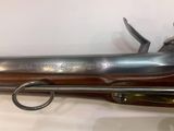 un fusil avec un canon en bois et une poignée en métal