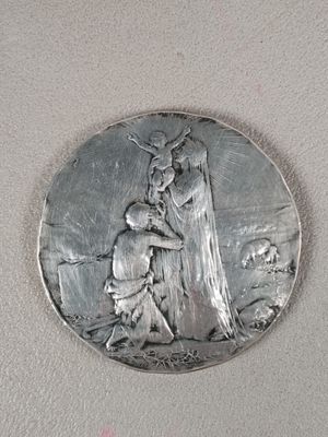 une image représentant une médaille d'argent sur laquelle figurent une femme et un enfant